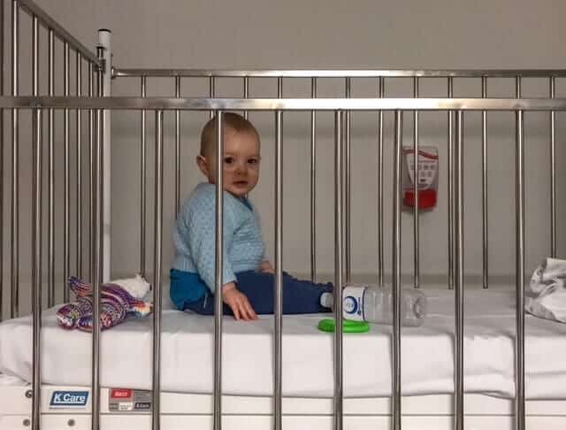 Baby in a hospital cot